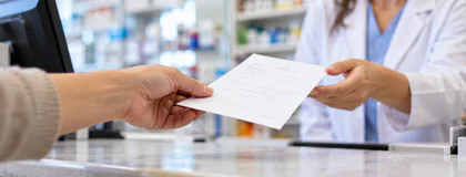 A hand holding a prescription